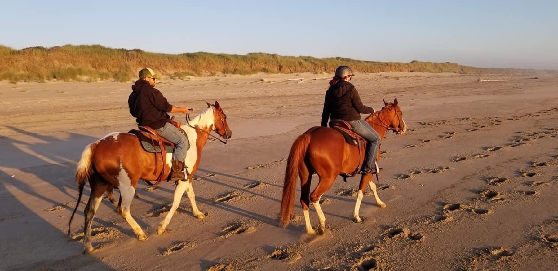 Riding horses on the Oregon coast at sunset